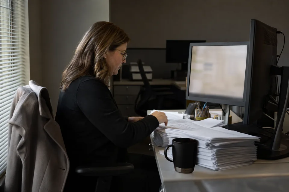 Bank deposit operations manager checking weekend instant payment settlement on a Monday morning before the branch opens