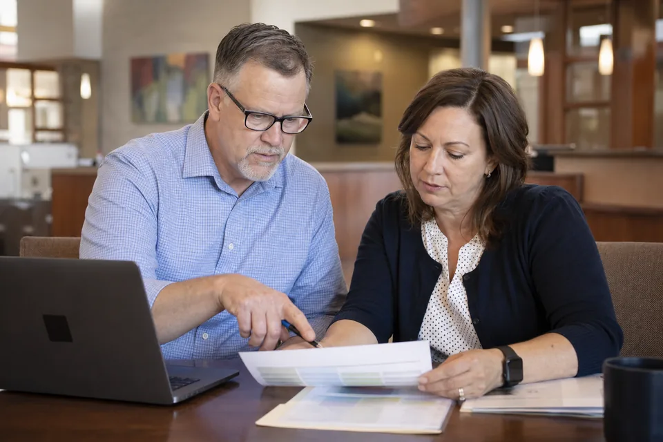 Credit union controller and accountant reviewing a reconciliation exception report together